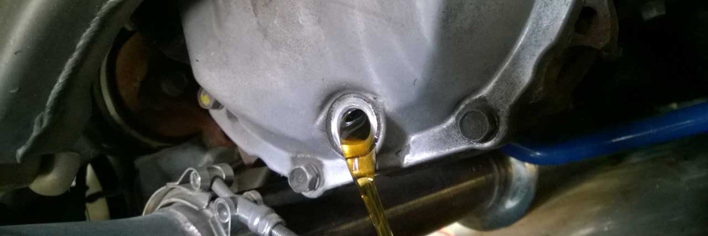 Yellow colored liquid being poured from a metal tank